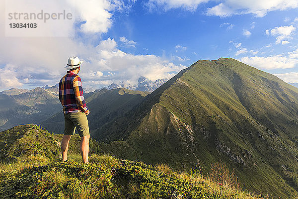 Mann auf dem Gipfel des Monte Rolla mit Blick auf den Monte Disgrazia und den Sasso Canale  Provinz Sondrio  Valtellina  Lombardei  Italien