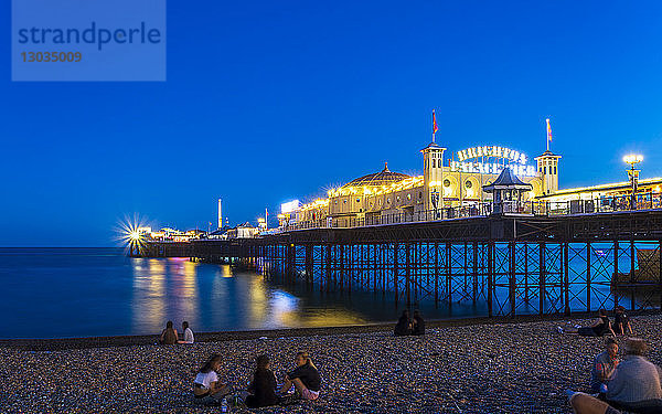 Brighton Palace Pier und Strand bei Nacht  East Sussex  England  Vereinigtes Königreich