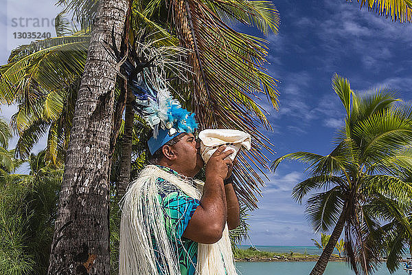 Ein Muschel blasender Krieger begrüßt die Gäste auf Aitutaki  Cook-Inseln  Südpazifische Inseln