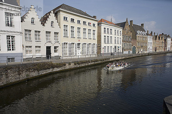 Spinolarei-Kanal mit Gebäuden auf der Sint-Annarei und herannahendem Boot mit Touristen  Brügge  Belgien