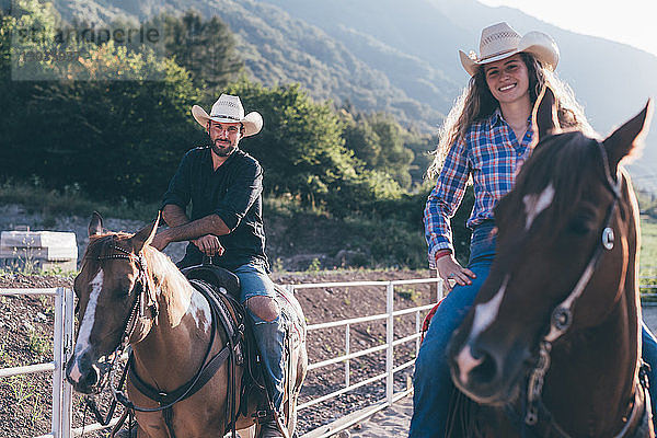 Kuhmädchen und Junge zu Pferd in der Reithalle  Porträt  Primaluna  Trentino-Südtirol  Italien