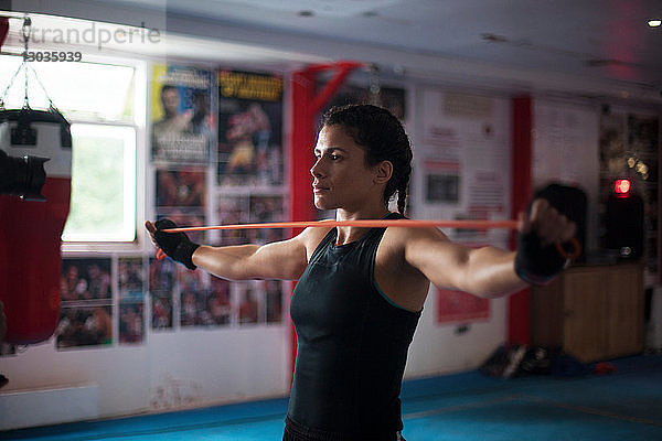 Boxerin macht Dehnübungen im Fitnessstudio