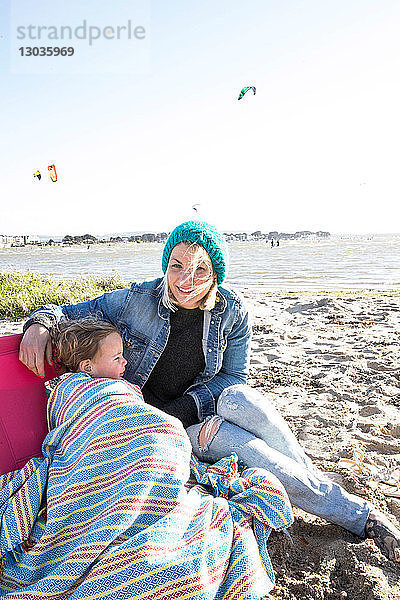 Mutter und Kleinkind Mädchen in Decke am Strand