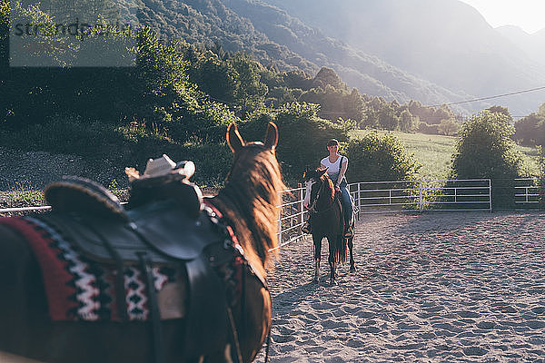 Junge Frau zu Pferd in ländlicher Reitarena  Primaluna  Trentino-Südtirol  Italien