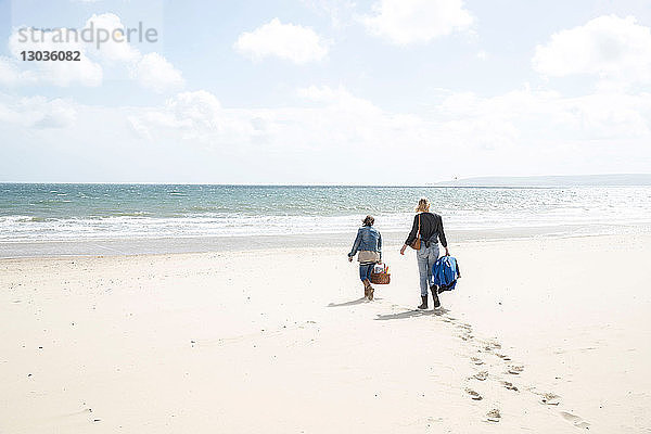 Schwestern gehen nach Picknick am Strand