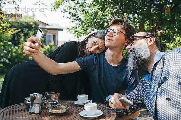 Eine Familie  die sich beim Kaffee auf der Terrasse selbstständig macht