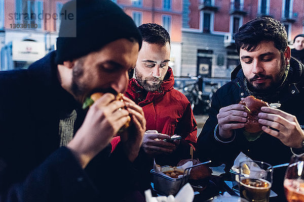 Freunde genießen Burger im Freiluftcafé  Mailand  Italien