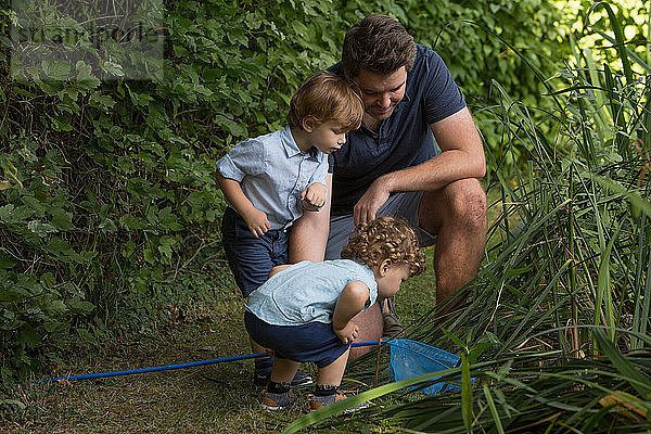 Vater und Kinder schauen im Fischernetz