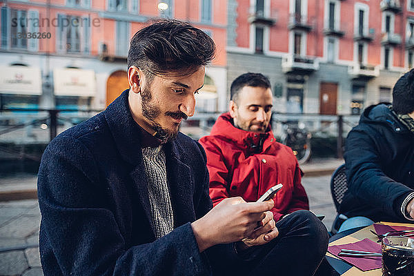 Mann benutzt Smartphone im Außencafé  Mailand  Italien