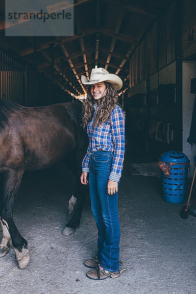 Junges Cowgirl am Stalleingang  Porträt