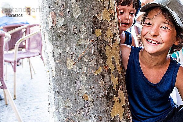 Jungen spielen am Baum