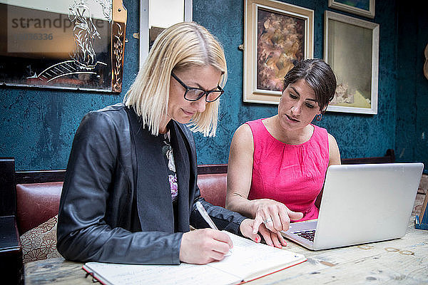 Frauen beim Brainstorming von Geschäftsideen im Restaurant