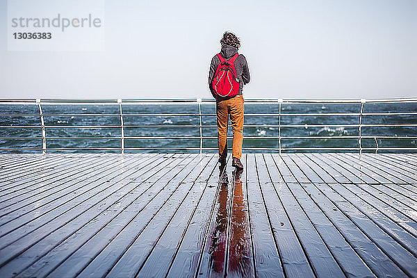 Mittelgroßer erwachsener Mann mit Blick vom Pier aufs Meer  Rückansicht  Odessa  Odeska Oblast  Ukraine