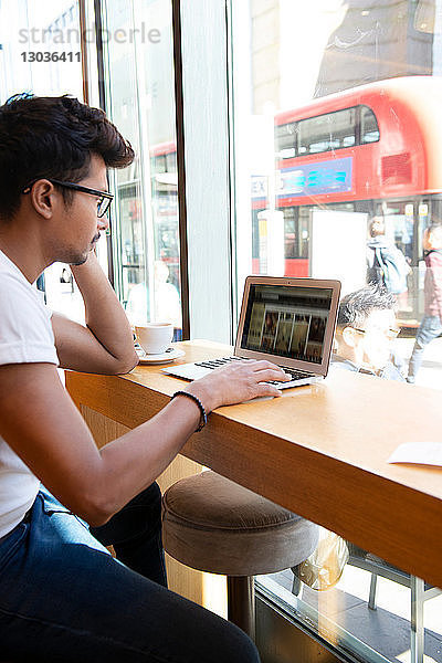 Mann benutzt Laptop im Café