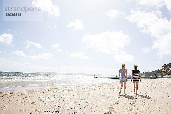 Schwestern gehen am Strand spazieren