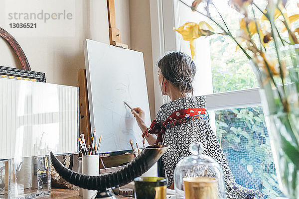 Frau arbeitet in ihrem Atelier an Entwürfen