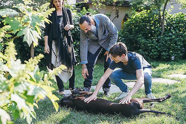 Ehepaar mit Sohn und Haushund im Garten