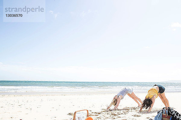 Schwestern genießen Yoga am Strand