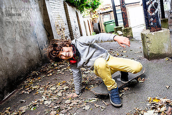 Junge fällt auf der Straße vom Skateboard