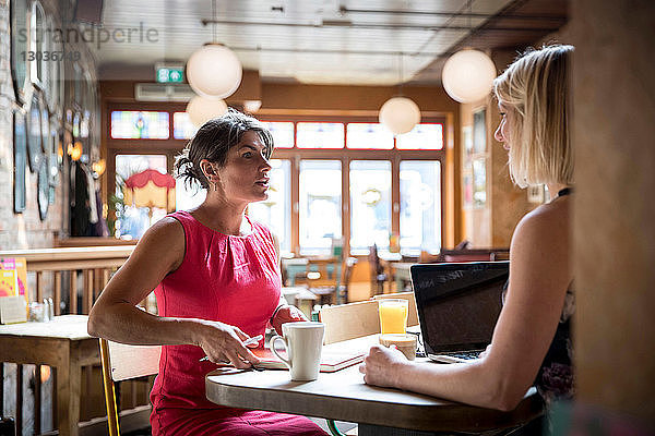 Frauen beim Brainstorming von Geschäftsideen im Restaurant