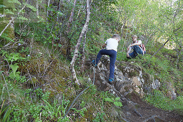 Junge und Vater klettern im Mooswald  Aure  More og Romsdal  Norwegen