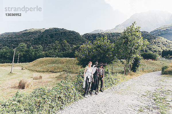 Junge erwachsene Wanderfreunde beim Daumenklauen auf ländlichem Feldweg  Primaluna  Trentino-Südtirol  Italien