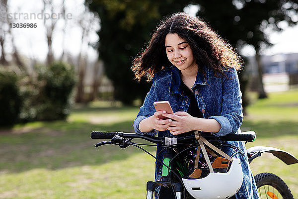 Teenager-Mädchen schreibt SMS auf dem Fahrrad