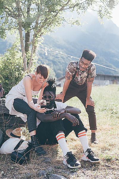 Drei junge erwachsene Wanderer vor Ort mit Smartphone im Blick  Primaluna  Trentino-Südtirol  Italien