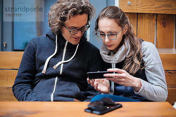 Paar benutzt Smartphone im Café