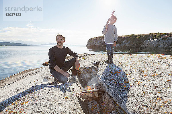Junge und Vater am Lagerfeuer am Einlauffelsen  Aure  More og Romsdal  Norwegen