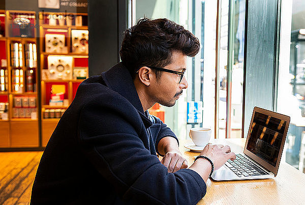 Geschäftsmann benutzt Laptop im Café