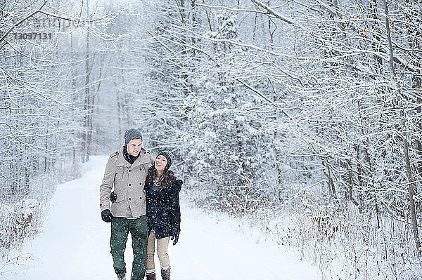 Romantisches junges Paar beim Spaziergang im verschneiten Wald  Ontario  Kanada