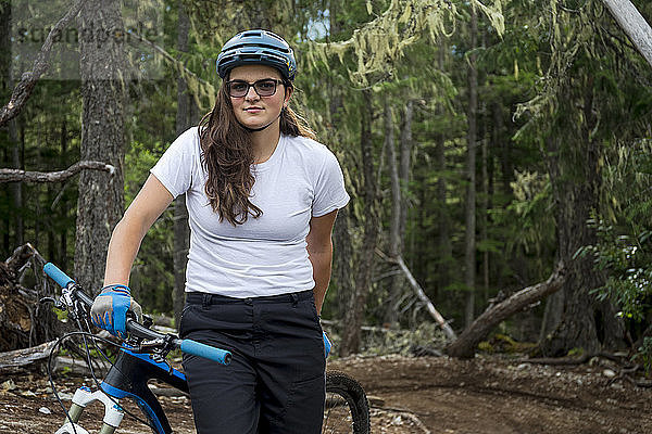 Hochformatiges Porträt einer abenteuerlustigen Mountainbikerin  Lost Lake Trails  Whistler  British Columbia  Kanada