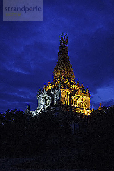 Lichter erhellen die Spitze einer Pagode nach Sonnenuntergang in Bagan  wo Tausende von alten Tempeln in einer offenen Ebene in Zentral-Myanmar zu finden sind. Die Tempel von Bagan sind eines der beliebtesten Reiseziele in Myanmar.