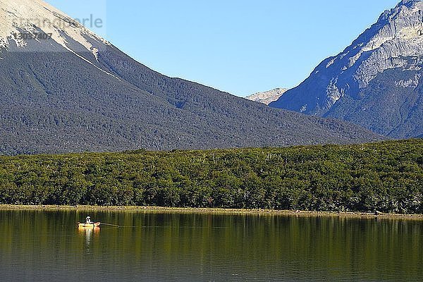 Landschaft mit Bergen und einem Mann  der in einem Kajak auf dem See Tres Valles angelt  Argentinien