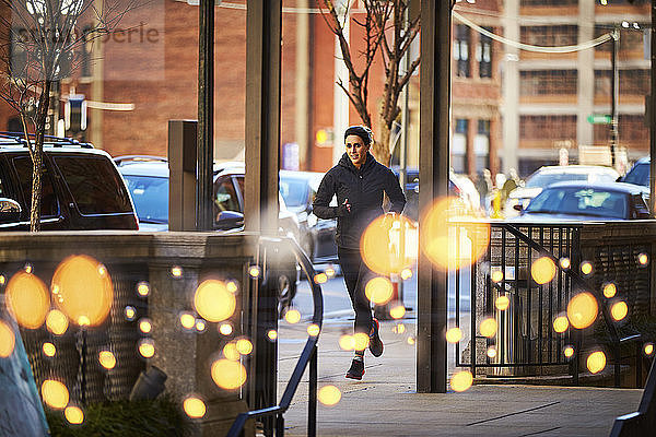 Totale Aufnahme einer alleinstehenden Frau beim Joggen in einer Stadt