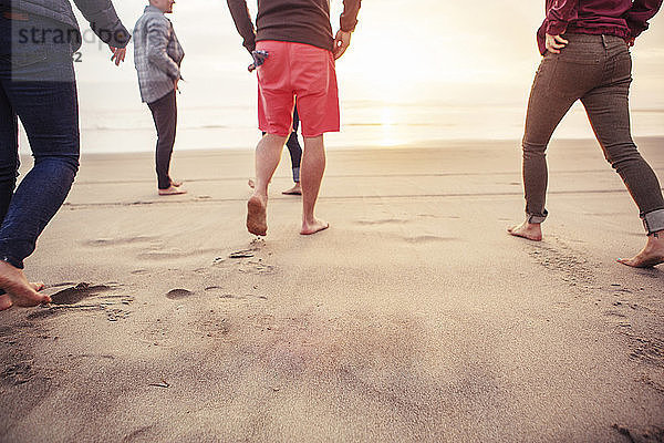 Niedriger Anteil von Freunden  die am Strand auf Sand laufen