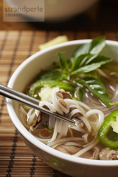 Nahaufnahme der in einer Schüssel auf dem Tisch servierten Pho-Suppe