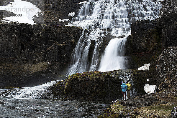 Rückansicht eines Paares  das steht und auf den Wasserfall schaut