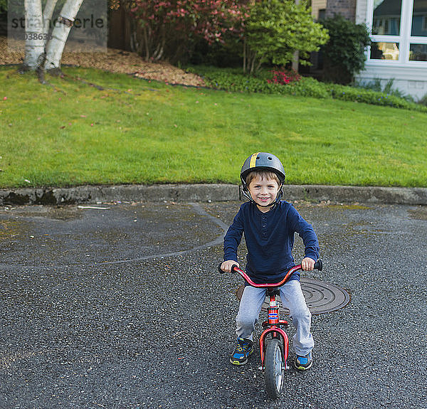 Porträt eines Jungen beim Fahrradfahren auf der Straße