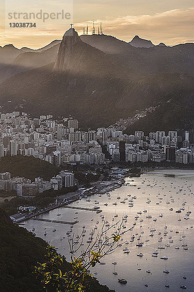 Luftaufnahme des Hafens nach Wohnvierteln gegen die Berge bei Sonnenuntergang