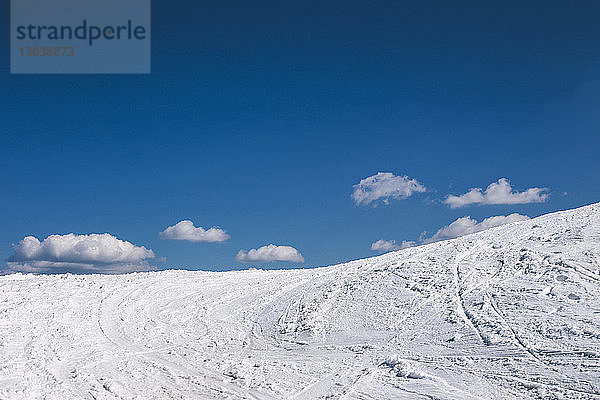 Schneebedecktes Feld vor blauem Himmel bei sonnigem Wetter