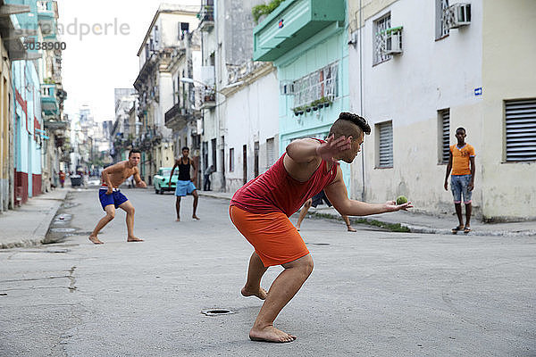 Freunde spielen mit dem Ball auf der Straße in der Stadt