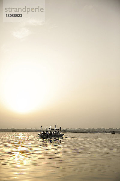 Menschen  die bei Sonnenuntergang im Boot reisen