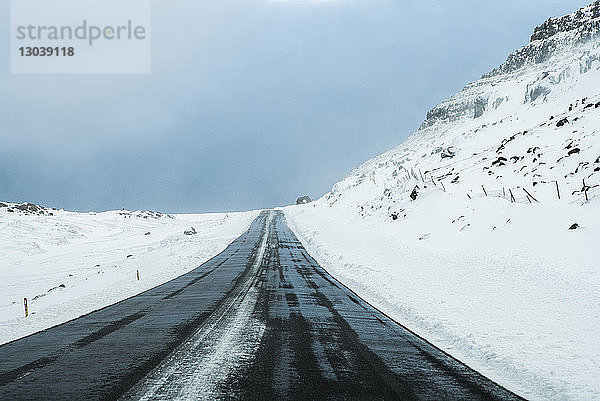 Szenische Ansicht der Straße inmitten eines schneebedeckten Feldes