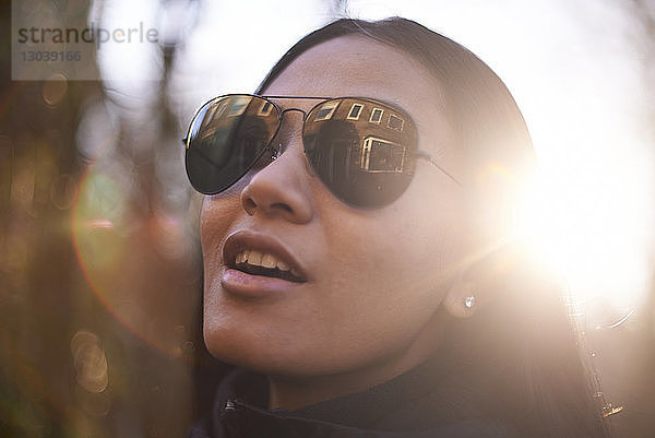 Nahaufnahme einer selbstbewussten Frau mit Sonnenbrille an einem sonnigen Tag in der Stadt