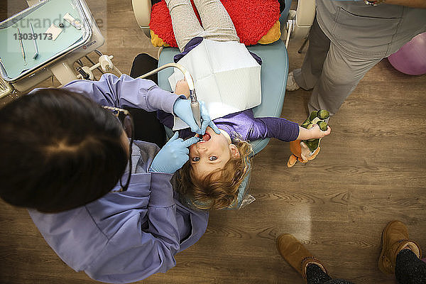 Draufsicht eines Zahnarztes  der ein Mädchen in der Klinik untersucht