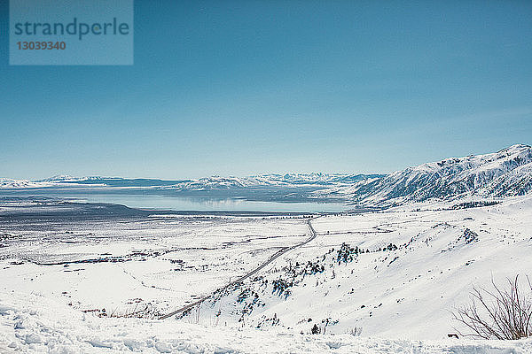 Szenenansicht einer schneebedeckten Landschaft vor klarem blauen Himmel