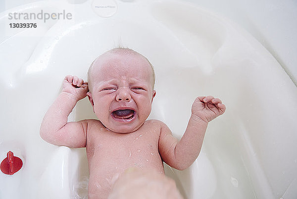 Hochwinkelaufnahme eines weinenden Mädchens in der Badewanne