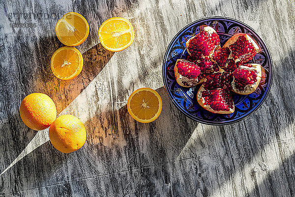Draufsicht auf Granatapfel und Orangen auf dem Tisch